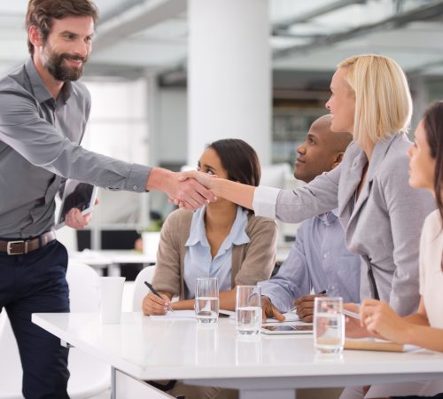 Shot of a businessman shaking the hands of his colleagues sitting on a panel
